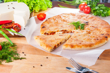 Selective Focus vegetable closed pies with cheese and sun-dried tomatoes on the table. Composition of ingridients.