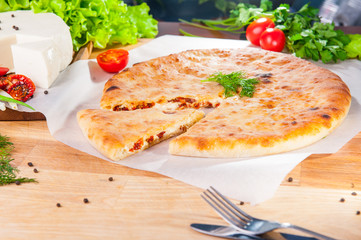 Selective Focus vegetable closed pies with cheese and sun-dried tomatoes on the table. Composition of ingridients.