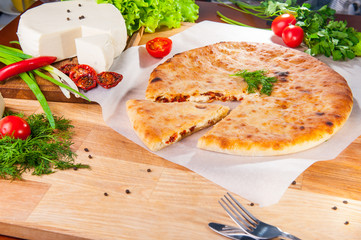Selective Focus vegetable closed pies with cheese and sun-dried tomatoes on the table. Composition of ingridients.