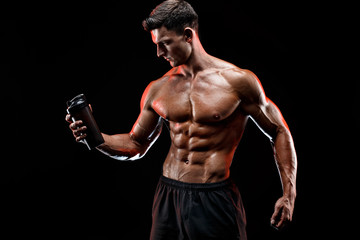 Muscular man with protein drink in shaker over dark background