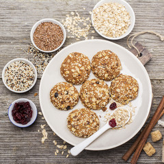 Multigrain Oatmeal cookies with flax seeds, sesame , dried cranberries, cane sugar on a ceramic dish   wooden background. Top view