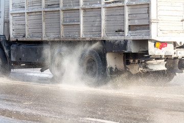 splashes from under the wheels of a truck on the road