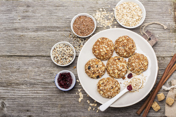 Multigrain Oatmeal cookies with flax seeds, sesame , dried cranberries, cane sugar on a ceramic dish   wooden background. Top view