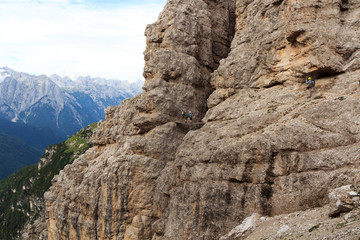 Man photographing people on the Via Ferrata Severino Casara with bridge in Sexten Dolomites mountains, South Tyrol, Italy