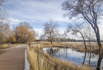 recreational and commuting bike trail along the Poudre River in Fort Collins, Colorado, typical winter scenery with some snow