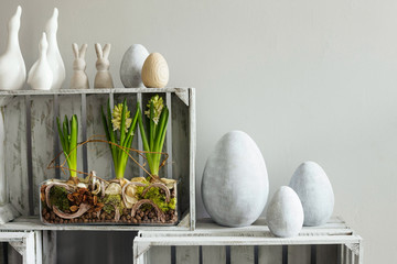 Simple, modern Easter decoration with concrete eggs on shabby chic wooden crates.