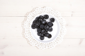 Traditional Dutch candy drop on little plate on wooden backgroun