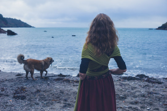 Young woman walking dog on beach
