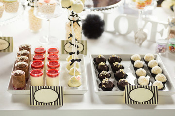 Black and white sweet table with hand made pralines, cake pops and strawberry panna cotta at an...