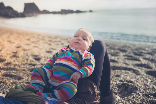 Young mother with baby relaxing on beach