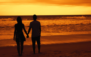 Liebespaar Hand in Hand am Strand bei Sonnenuntergang