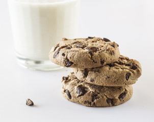 Biscuits with chocolate chips inside and a glass of milk.