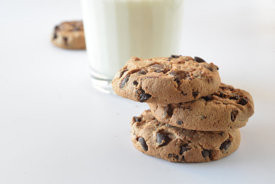 Biscuits with chocolate chips inside and a glass of milk.