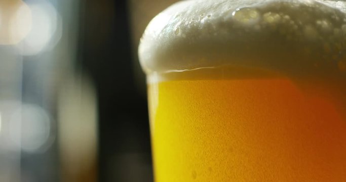 golden icy cold beer in extreme macro foam. clear beverage and bubbles of carbon dioxide. fresh beer of double-hop just poured. concept of fresh and thirst-quenching beer. texture and extreme macro 