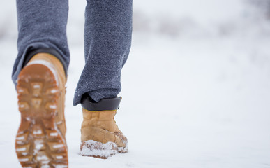 Closeup of male yellow winter shoes on snow