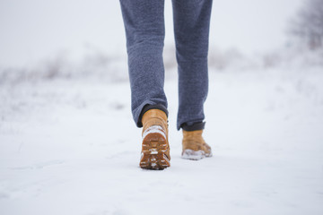 Closeup of male yellow winter shoes on snow