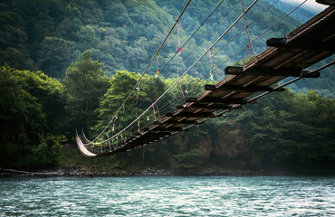 The bridge across the river. Natural landscape with mountains.