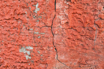 Red, plastered walls with cracks and irregularities