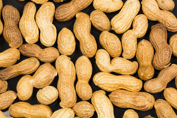 Peanuts in shell with black background texture