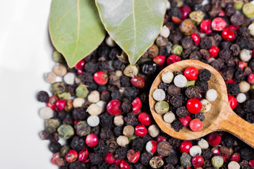 Spices closeup. A mixture of peppers in a wooden spoon.