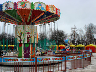 Children's bright carousel chain in the center of the square close-up in the winter season