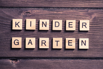 wooden elements with letter collected to word kinder garten