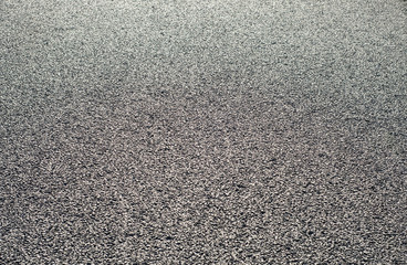 Asphalt black surface with gravel closeup as background