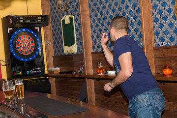Young man playing darts in a club