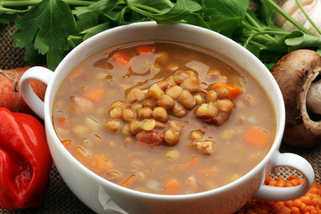 Lentil soup with pita bread in a bowl on a wooden background