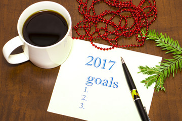 2017 list of goals on paper, a wooden table with a Cup of coffee