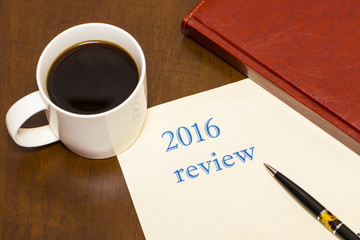 The 2016 review the text on the sheet of paper next to a Cup of