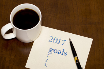 2017 list of goals on paper, a wooden table with a Cup of coffee