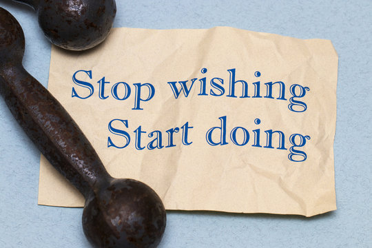 Stop wishing, start doing! Motivational phrase on a sheet of pap