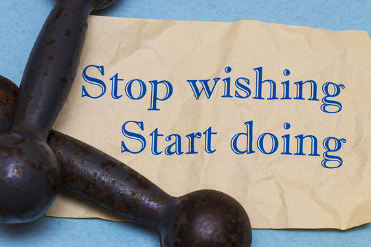 Stop wishing, start doing! Motivational phrase on a sheet of pap