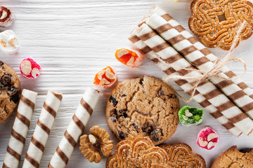 a variety of cookies and sweets on a white wooden table