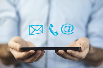Man using tablet  while emitting a clouds of contact icons in a