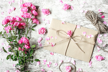 Bouquet of tender pink roses with envelope and rope