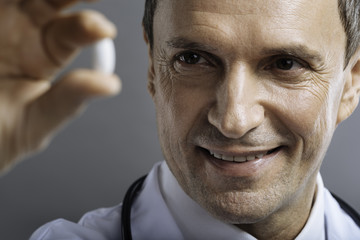 Close up of glad doctor holding a pill
