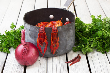 Fresh steamed crayfish. Two crayfish hanging on the tails. Boiled crawfish with parsley and spices. Rustic style. Wooden background. - Powered by Adobe
