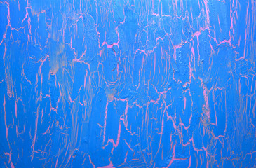 Cracked blue paint on the pink surface