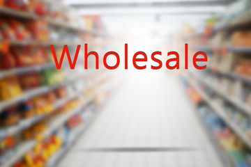 Word WHOLESALE on blurred supermarket background