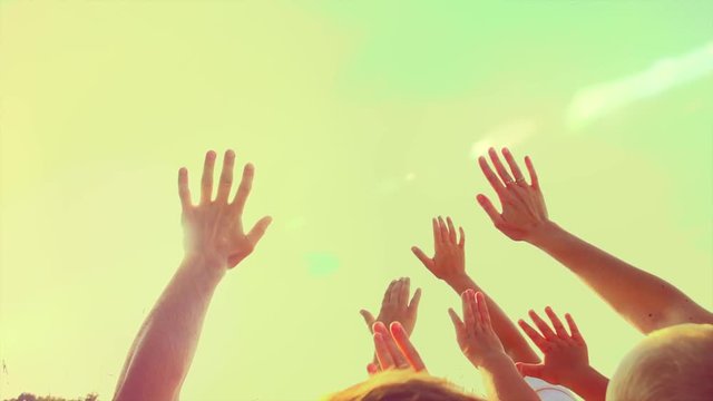Happy big family raising hands up, Father, mother and children - little sons together enjoying nature outdoors. Hands silhouette over sunset sky. Vacation concept. Slow motion 240 fps. Full HD 1080p