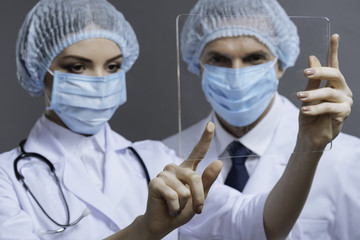 Concentrated colleagues touching medical glass