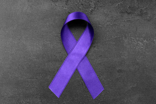 Violet ribbon on dark background. Family violence, Alzheimer disease and pancreas cancer concept
