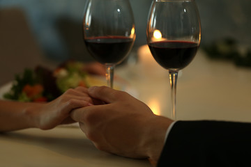 Couple holding their hands in restaurant