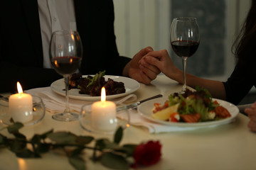Couple holding their hands in restaurant