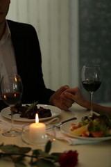 Couple holding their hands in restaurant
