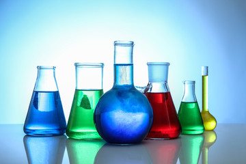 Chemical flasks on light background