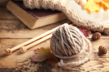 Knitting wool and needles on wooden table