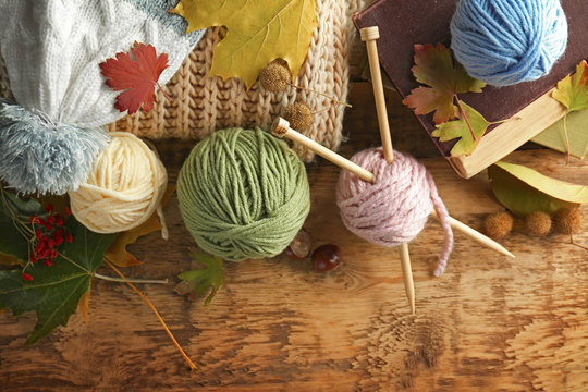 Knitting wool and needles on wooden table